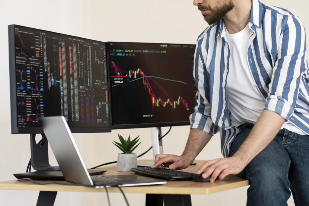 trader-analysing-trading-charts-on-desktop-while-sitting-on-table – PU Prime | More Than Trading trader analysing trading charts on desktop while sitting on table
